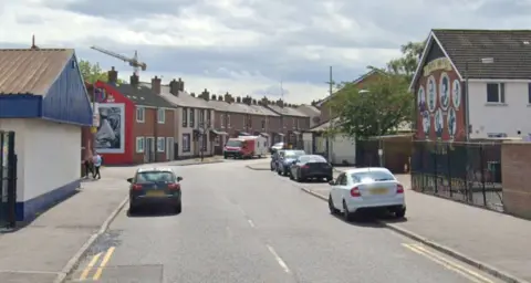 Google view of Templemore Street, showing red brick buildings, one with a mural, and a tree with some cars parked alongside pavement 