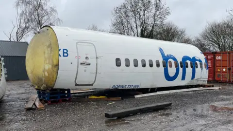 Rear half of an aircraft fuselage in a scrapyard