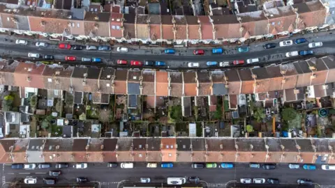 An aerial drone photo showing rows of housing in Bristol and streets lined with cars. 
