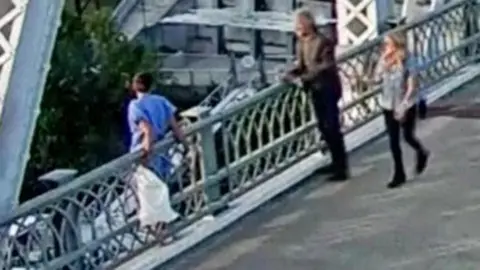 A low quality grab shows Jon Bon Jovi speaking to the woman on the bride, with a passer by in frame