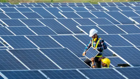 Getty Images Technicians fitting solar panels