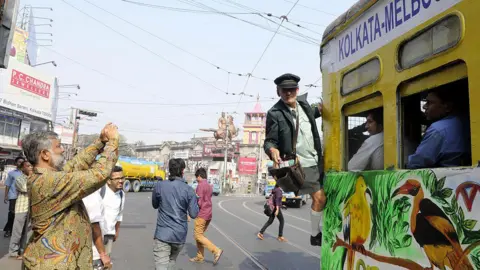 AFP oberto D'Andrea, tram conductor of Melbourne, enjoying the joyride in a newly decorated tram to celebrate the 20th anniversary (1996 - 2016) of Kolkata Melbourne Tramjatra approaching Esplanade, on December 10, 2016 in Kolkata, Indi