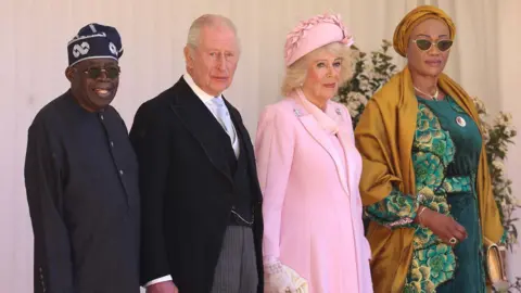 King Charles III with the President of Nigeria Bola Ahmed Tinubu . Also pictured is Queen Camillla wearing pink and First Lady Oluremi Tinubu in green and yellow.