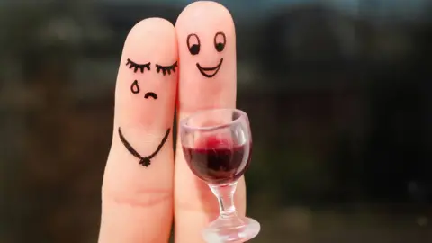 Getty Images Fingers with happy and sad faces drawn on them