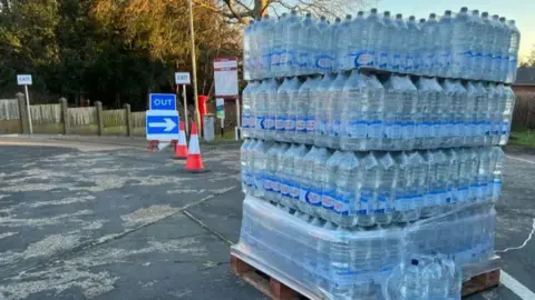 A wooden pallet with bottled water on top