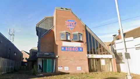 A derelict Bingo hall called 'Ritz Bingo' on a sunny day.