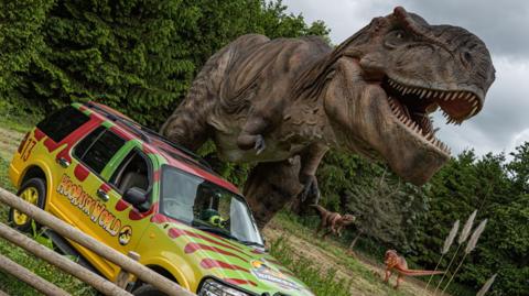 A dinosaur and a car