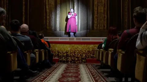 Seorang wanita berdiri di atas panggung saat pertunjukan teater di Dnipro