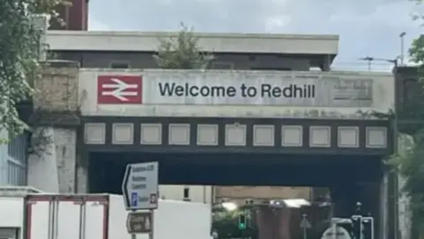 BBC A sign on a railway bridge by Redhill station saying 'Welcome to Redhill'