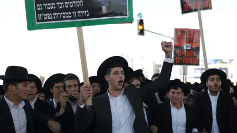 EPA Ultra-Orthodox Jewish men shout slogans during a protest against Israeli military conscription, in Jerusalem (30 October 2025)