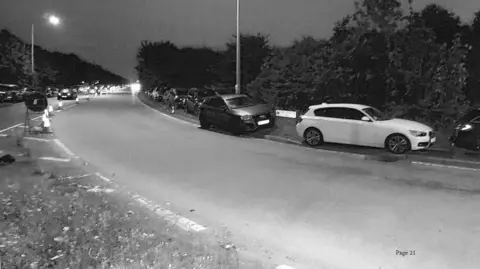 LDRS A black and white image of cars parked on the curb on Regiment way in Essex during a festival in September 2021