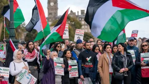 PA Media Crowds in Edinburgh held Palestinian flags as they attended the protest