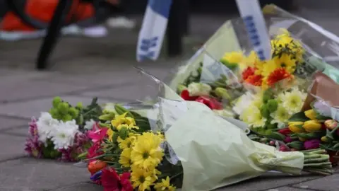 PA Flowers placed at the scene in West Kensington where a teenager was fatally stabbed on 7 March