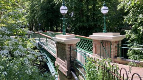 A Victorian brick bridge with lamps leads the way into Belle Vue Park 