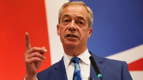 Nigel Farage speaks into a microphone in front of a Union Jack backdrop