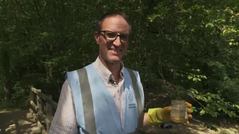 A man holds a jug of water. 