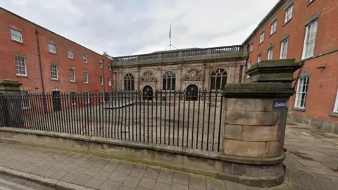 Google A old court building with a stone courtyard.