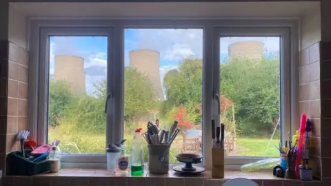 The cooling towers can be seen from a kitchen window.