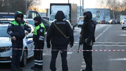 Law enforcement officers block the road near the scene where two traffic police officers and another person were killed in a blast in Moscow, Russia December 24, 2025 