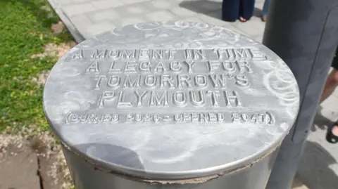 Plymouth City Council The metal cylinder before it was dropped into place underground. It was marked with the words "A moment in time. A legacy for tomorrow's Plymouth - (buried 2026, opened 2057)"