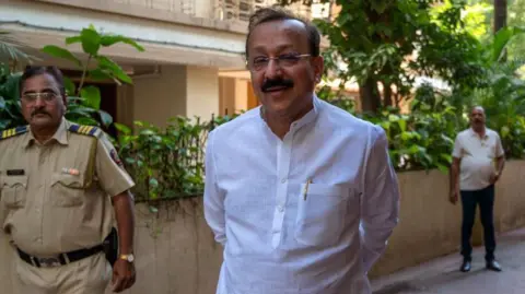 Getty Images Baba Siddique interacts with media after he quits Congress party on February 8, 2024 in Mumbai, India. 