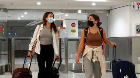 Getty Images Travelers exit from the International arrivals door at Miami International Airport.