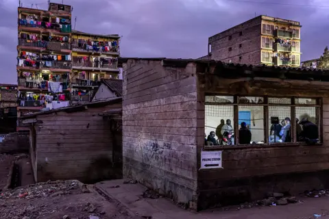 Luis Tato / AFP Electoral Commission Officials count votes inside a polling station after the official closing of the polls during Kenya's general election at Mathare North Social Hall in Nairobi on 9 August 2022