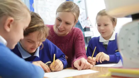 Getty Images Generic image of teacher helping pupils