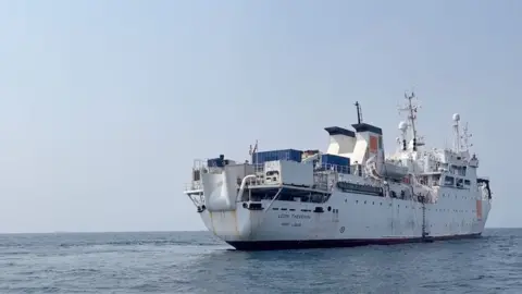 Lyon Thinnin - a large white ship - appears at sea