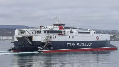 The Manannan ferry, which is white black and red and has 'Steam-Packet.com' written on the side, in Douglas Bay.