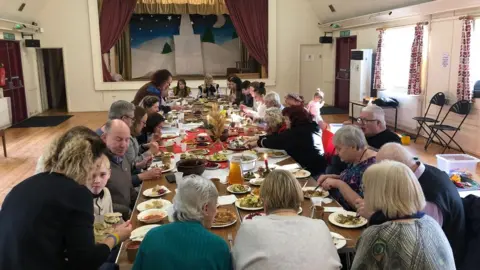 BBC People sitting around a big dinner table