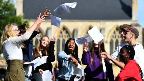 PA Media Somto Elumogo (centre) and other students celebrate with their GCSE results at Norwich School in Norwich, Norfolk