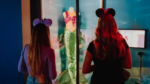 Luke Dyson Two girls looking at Little Mermaid costume