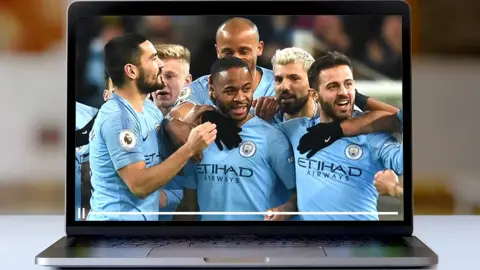 Getty Images Man City players celebrate on a laptop