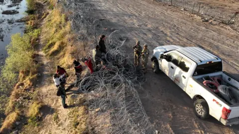 Getty Images EL PASO, TEXAS, US - MARCH 3: Migrants attempting to cross the North American side of the border between El Paso and Ciudad Juarez, Mexico in Texas, United States on March 3, 2024.The Texas government continues to increase security on the border between El Paso and Ciudad Juarez, with a new metal barrier that already extends more than 2.5 kilometers across the Rio Grande.