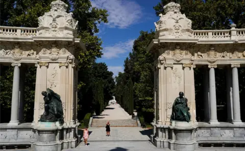 Reuters A woman takes pictures at Retiro Park on the day that Unesco added Madrid's historic Paseo del Prado boulevard and Retiro Park to its list of world heritage sites, in Madrid, Spain, 25 July 2021