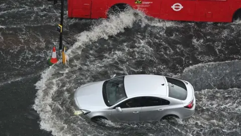 Getty Images Car driving through flood water