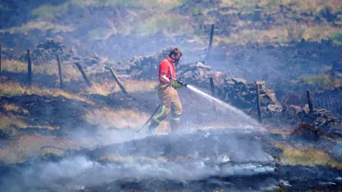 Getty Images Firefighter tackles the blaze on Winter Hill