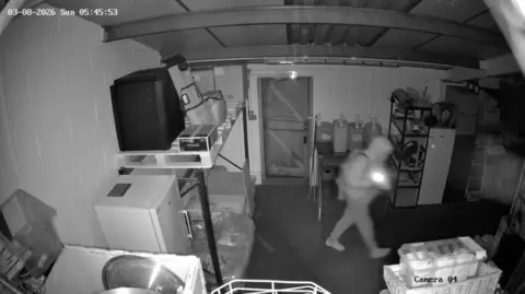 CCTV footage of a hooded figure in a backroom of a pub 