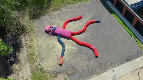 Aerial view of the sock monkey lying on concrete
