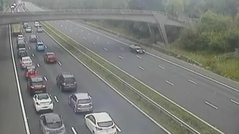 National Highways  A traffic camera image of the M4, with traffic queueing along the road. 