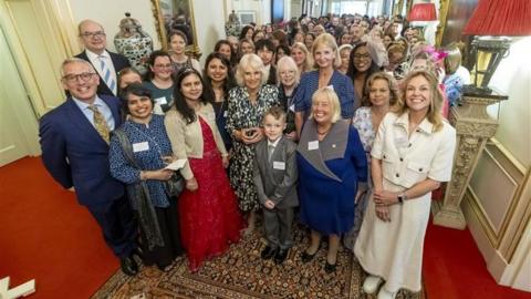 Jayden pictured with Queen Camilla and other attendants
