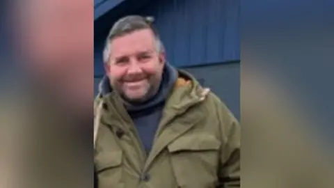 Leicestershire Police Simon Geary wearing a jacket and a navy blue hoodie