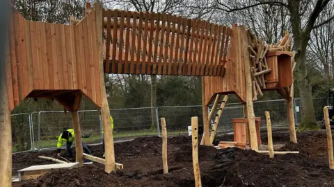 Nene Park Trust Wooden slides and play equipment placed in the soil.