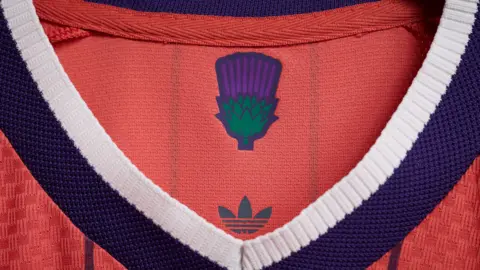Scottish FA The salmon-pink Scotland away strip with a green and purple thistle on the inside.