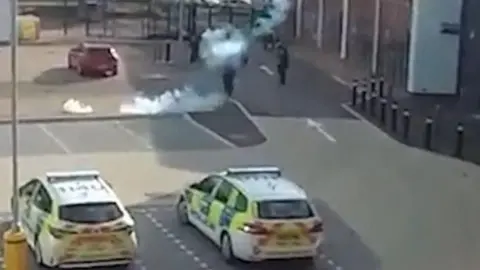 Derbyshire Police A slighty blurry CCTV image showing Mr Ciolac surrounded by officers in a car park