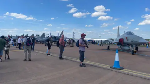 People with cameras looking at planes on the tarmac at RIAT