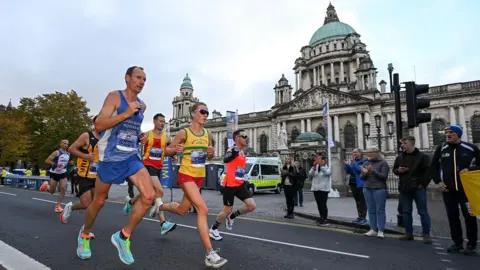 Runners pass Belfast City Hall. 