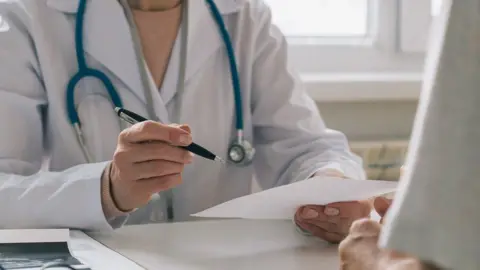 Getty Images A GP talking to a patient