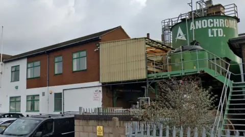 Google A two-storey white and brick building, with a large green storage tank to the right of the property, emblazoned with the words Anochrome Ltd